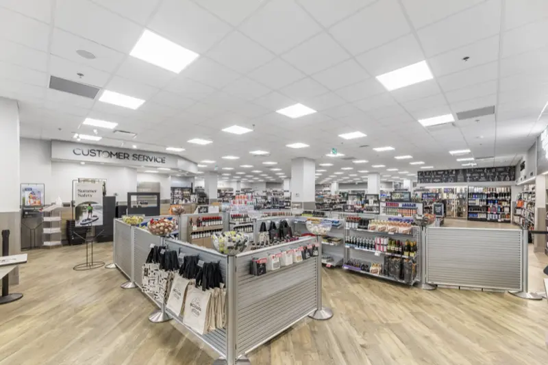 Wide view of a liquor store sales floor with shelving and a customer service counter